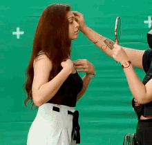 a woman is looking at herself in a mirror with a plus sign in the background