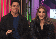 a man and a woman are smiling in front of a sign that says " da fae "