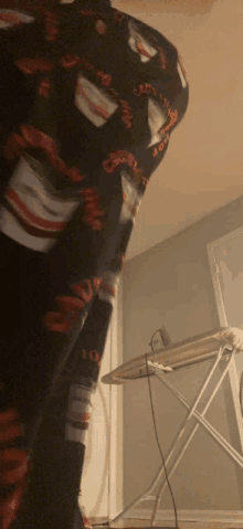 a person standing in front of an ironing board wearing a sweater that says chicago