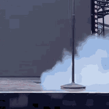 a microphone is sitting on a stage with smoke coming out of it .
