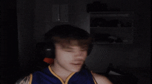 a man wearing headphones and a blue and yellow jersey is laughing