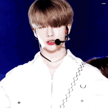 a close up of a person wearing a white shirt and a microphone