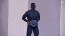 a man without a shirt is wearing a wrestling belt with a blue w on it