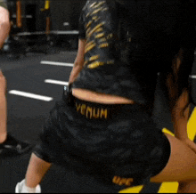a person wearing black shorts that say venum ufc