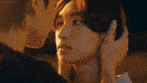 a man and a woman are touching each other 's faces and looking at each other .