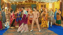a man and a woman are dancing in front of a crowd of people at a wedding reception .