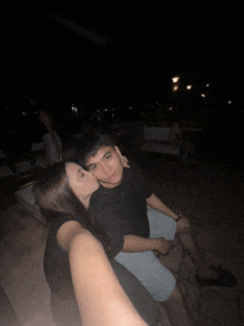 a woman kisses a man on the cheek in a dark room