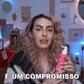 a woman holding a pink bottle with the words e um compromisso written on it