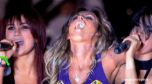 three women singing into microphones with anahioverdose written on the bottom right