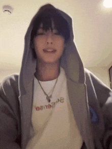 a young man wearing a hoodie and a t-shirt that says ' oenoe ' on it