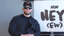 a man stands in front of a sign that says hey