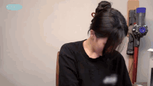 a woman sitting in front of a vacuum cleaner with mina tv written on the bottom of the screen
