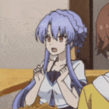 a girl with blue hair is sitting at a table with another girl