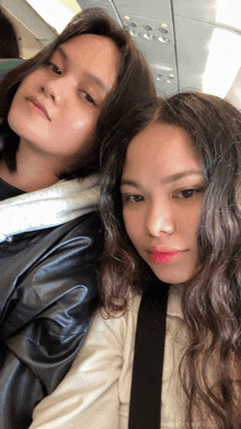 two girls are posing for a picture and one has red lipstick
