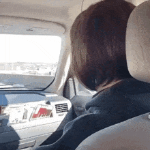 a woman sits in the driver 's seat of a car