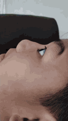 a close up of a person 's face with their eyes looking down