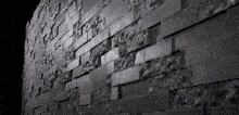 a black and white photo of a wall with bricks on it