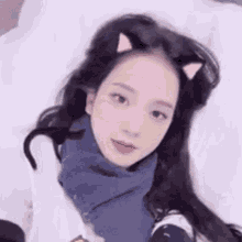 a close up of a woman laying on a bed with cat ears on her head .