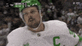a hockey player wearing a green helmet with the letter c on it