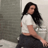 a woman is sitting on a toilet with a tiktok watermark on the bottom
