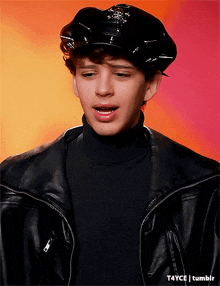 a young man wearing a police hat and a black jacket