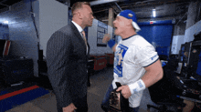 two men are standing next to each other in a room with a sign that says back to the roots