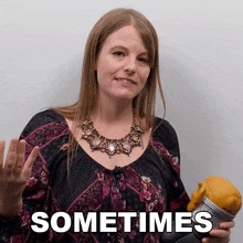 a woman in a floral shirt is holding a skull and the word sometimes is above her