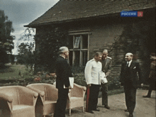 a group of men standing in front of a building with a sign that says " russia "
