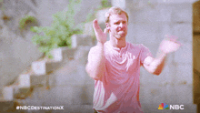 a man in a pink shirt is clapping in a nbc destination x advertisement