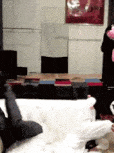 a person is sitting on a couch in a living room holding a pink stuffed animal .