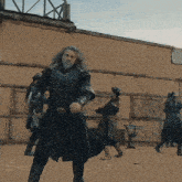 a man with long hair and a beard is holding a sword and shield