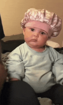 a baby wearing a chef 's hat is sitting on a bed