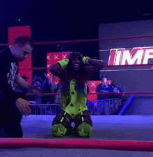 a wrestler kneeling down in front of a sign that says imf on it