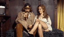 мужчина и женщина сидят на диване GIF