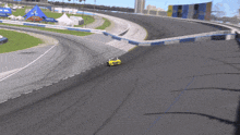 a yellow race car is going around a curve on a track