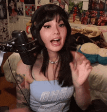 a young woman wearing headphones is sitting in front of a microphone .