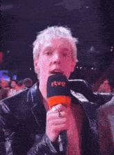a man is holding a microphone that says rtve