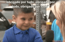 a boy in a blue shirt is talking to a woman with the words " obrigado por tudo " on the bottom