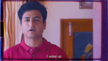 a man in a red shirt is saying " i wake up "