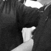 a black and white photo of a person 's hand covering their face .