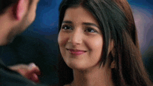 a close up of a woman looking at a man 's face and smiling .