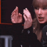 a woman wearing headphones and a black sweater is giving the middle finger