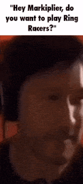 a close up of a man 's face with the words " hey markiplier do you want to play ring racers "