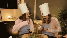 two women in chef hats with the letter p on them