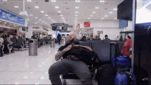 a man is sitting in a waiting area with a sign that says hudson