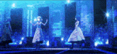 a group of anime girls are dancing on a stage with a city skyline in the background