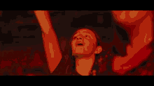 a man in a dark room with his arms in the air and his mouth open