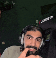 a man with a beard is wearing headphones and a leader seat
