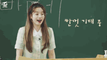 a group of girls are sitting at desks in a classroom with a yellow sign that says 21