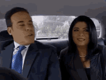 a man and a woman are sitting in the back of a car